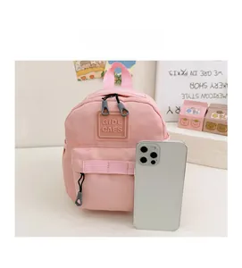 Comparaison de taille d'un mini sac à dos rose pour enfant avec un smartphone