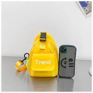 Yellow nylon kids chest bag with Trend lettering and phone for size reference