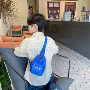 Kids blue nylon chest bag with white Trend lettering and adjustable green strap