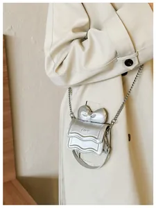 Detail of silver mini crossbody bag featuring a bow and wave edge with chain strap