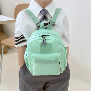 Sac à dos enfant vert menthe en nylon imperméable porté par un modèle pour l'extérieur
