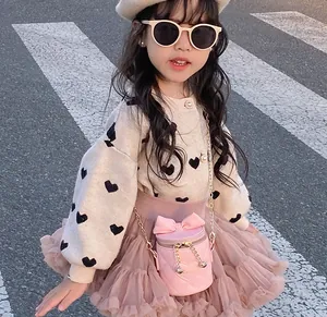 Detail of pink quilted bucket bag with bow and love embroidery for girls outfit