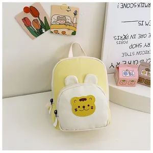 Detail of canvas mini backpack with cartoon bear patch in yellow and cream white