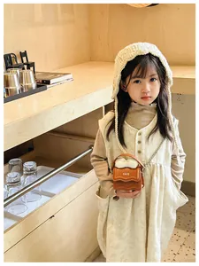 Detailed view of child mini brown crossbody bag with white bow and FAVE lettering