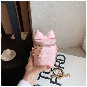 Close-up of pink quilted bucket bag with a bow and gold chain strap for kids