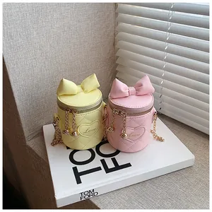Detail of quilted leather bucket bags with bow accent and gold chain straps