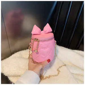 Detailed view of pink quilted bucket bag featuring a bow, heart embroidery and gold chain