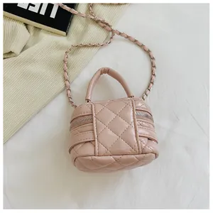 Detail van roze gewatteerde mini-tas met dubbele ritssluiting en een metalen ketting