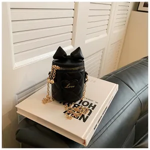 Detail of black quilted bucket bag featuring a bow, gold chain, and Love heart embroidery