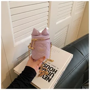 Detail of purple quilted bucket bag with bow accent and heart embroidery on white book
