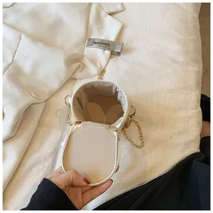Top view of compact cylindrical bucket bag interior with soft lining and chain strap