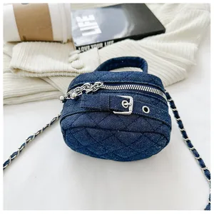 Close-up of quilted denim mini crossbody bag with silver chain strap and top handle