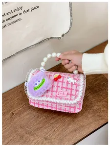 Detail van roze tweed handtas voor meisjes met parelhandvat en cartoon patches