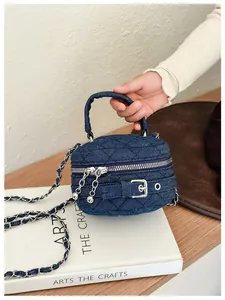 Detail of blue quilted denim mini round bag with silver chain strap and top handle