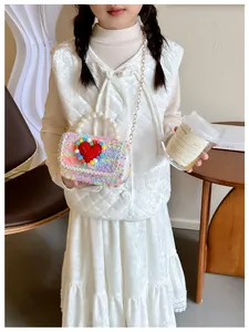 Ragazza con borsa di peluche colorata con cuore, manico di perle e catena d'oro