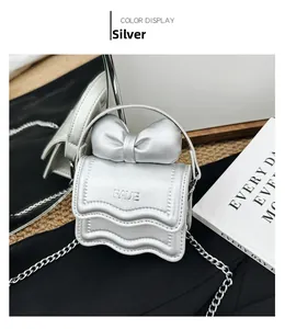 Macro detail of silver mini bag with 3D bow, wave flap and metallic FAVE logo