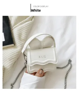 Detailed macro view of white mini handbag with bow decor and silver FAVE lettering