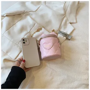 Detail of pink quilted mini bucket bag with gold chain strap and embroidered heart