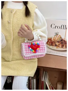 Dettaglio borsa in tweed a quadri rosa con cuore rosso, pizzo e manico di perle