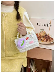 Detail van tweed meisjes handtas met parels, cartoon patches en kanten afwerking