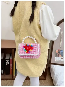 Dettaglio borsa a tracolla in tweed rosa per bambina con manico di perle e cuore
