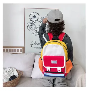 Back view of a child wearing a colorful patchwork canvas backpack in a modern home setting