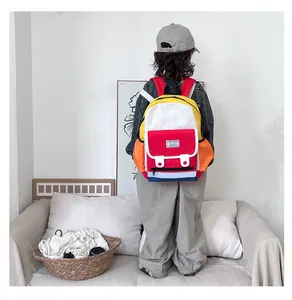Detail of colorful patchwork schoolbag with red front pocket and fashion label