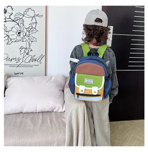 Kid back view wearing a colorful color-block backpack with adjustable green shoulder straps