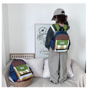 Detailed view of color-block kids backpack with thick green straps and front pocket