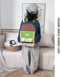 Toddler wearing a colorful patchwork backpack with multiple pockets in a home setting
