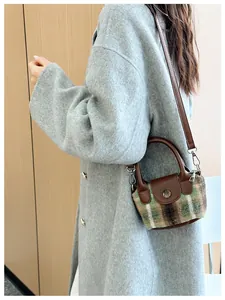 Dettaglio mini borsa vintage a quadri con tracolla in pelle marrone e ganci metallici