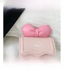 Detailed close-up of a pink mini crossbody bag featuring a large bow and silver FAVE logo