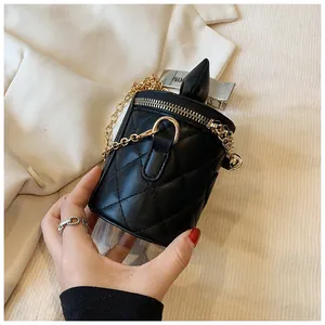 Close-up of black quilted bucket bag with gold chain strap and metallic zipper detail