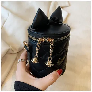 Detail of black quilted bucket bag featuring a large bow and Love heart embroidery