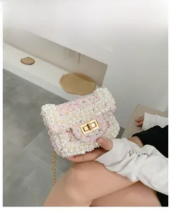 Detail of pink tweed shoulder bag with white faux pearl trim and gold chain handle