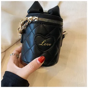 Detailed view of black quilted bucket bag with golden Love embroidery and bow decor