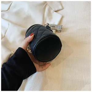 Detail of black quilted bucket bag featuring elegant gold zipper and chain strap hardware