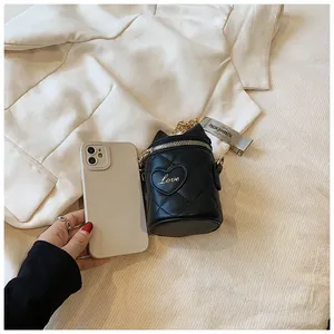 Detailed close-up of mini quilted bucket bag with cat ears and gold chain strap size comparison