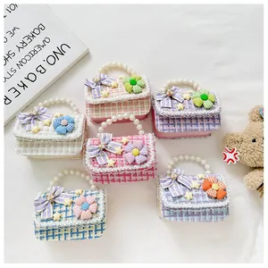 Detailopname van zes tweed mini-handtassen voor meisjes met parelhandvatten en strikjes