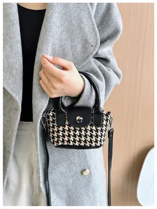 Vista macro della mini borsa in tweed per bambini con patta in pelle e tracolla