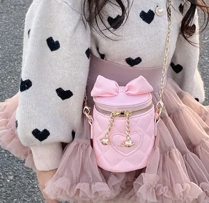 Detail of pink quilted bucket bag with gold Love lettering and large bow decoration