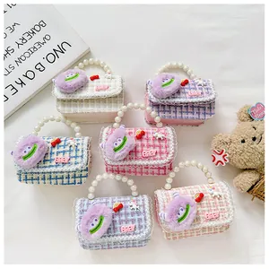 Detail van kinderhandtassen van tweed met parelhandvatten en kleurrijke eenhoorn patches