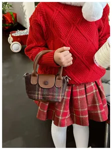 Dettaglio della mini borsa a quadri in tweed per bambini con patta in pelle marrone