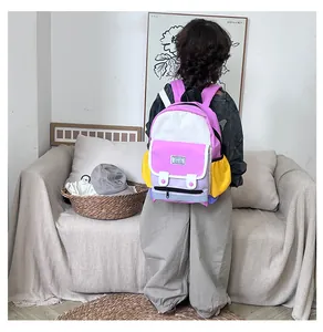 Detail of color-block kids backpack with multiple pockets on a child model