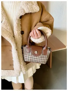 Dettaglio della borsa vintage a quadri per bambini con cappotto marrone in shearling