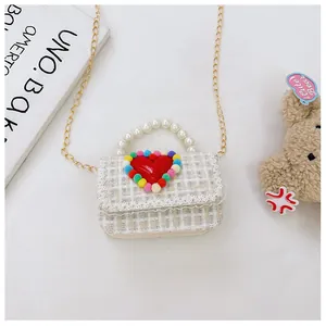 Dettaglio borsa bimba in tweed con manico di perle e finiture in pizzo color crema