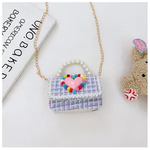 Dettaglio borsa a tracolla per bambini in tweed con manico di perle e cuore rosa