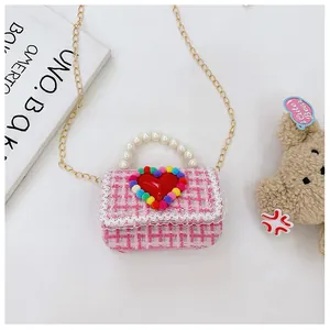 Dettaglio borsa in tweed rosa per bambina con grande cuore rosso e manico di perle