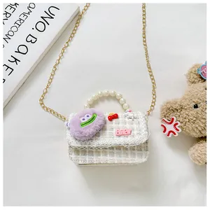 Detail van tweed kindertas met parelhandvat, pluche monster en BABY belettering