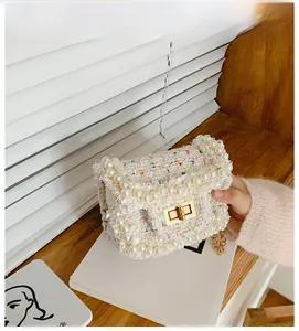 Detailed view of princess style tweed mini bag with pearl trim and gold chain strap
